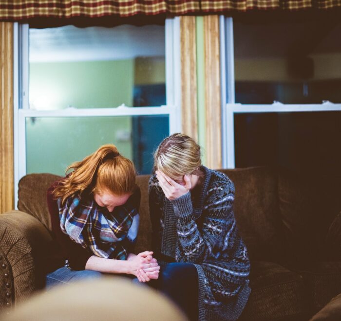 man and woman sitting on sofa in a room