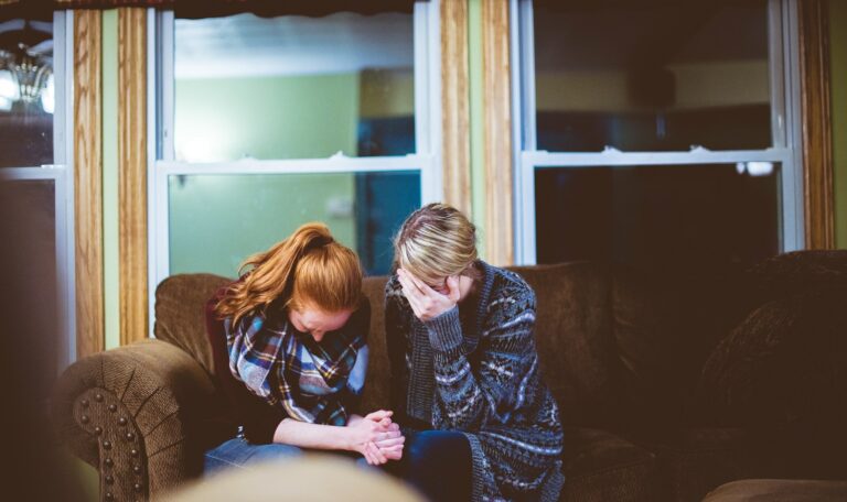 man and woman sitting on sofa in a room